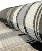 A close-up view of a rolled-up fabric with a striped pattern. Produktbild-Vorschau