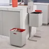 A kitchen scene with two recycling bins and a person preparing food. Podgląd zdjęcia produktu