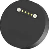 A close-up, top-down view of a black circular charging dock with gold and white charging pins. Anteprima dell’immagine prodotto