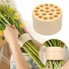 Beiges Blumenarrangierwerkzeug mit mehreren Löchern, in Gebrauch gezeigt, wie es einen Blumenstrauß hält Anteprima dell’immagine prodotto