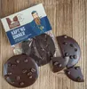 A package of chocolate with coffee beans on a wooden surface. Produktbild-Vorschau