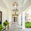 A covered porch with a hanging lantern, stone flooring, and plants. Voir les images du produit