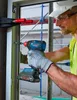 A construction worker is using a Bosch impact driver to install a window frame. Náhľad obrázku produktu