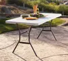 A white folding table set up outdoors on a patio with food and drinks on it. Produktbild-Vorschau