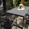 An outdoor dining set with a table and chairs on a patio. Produktbild-Vorschau