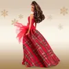 A Barbie doll wearing a red plaid dress, with gold snowflakes in the background. Náhľad obrázku produktu