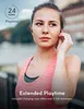 A woman wearing earbuds and a pink tank top, looking to the side. Voir les images du produit