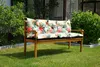A wooden garden bench with floral cushions sits on a green lawn in front of bushes and a building. Produktbild-Vorschau