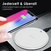 A hand is holding a smartphone over a wireless charging pad. Produktbild-Vorschau