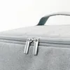 Close-up of the zippers and handle of a gray bag. Anteprima dell’immagine prodotto