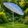 A striped beach umbrella is set up in a garden with lush green grass and blooming flowers. Náhled obrázku produktu