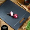 A cutting board with a red onion and a knife on a wooden table. Anteprima dell’immagine prodotto