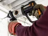 A person wearing work gloves is using a WORX hammer drill to drill into a ceiling. Náhled obrázku produktu
