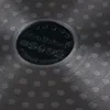 Close-up of the bottom of a pot with a textured surface and a central embossed logo. Podgląd zdjęcia produktu