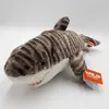 A plush toy shark with tiger stripes is lying on a white surface. Produktbild-Vorschau