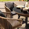 Outdoor patio furniture set with chairs and a table on a wooden deck. Produktbild-Vorschau
