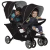 Two young children sitting in a double stroller. Voir les images du produit