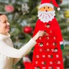 A woman is interacting with a Santa-themed advent calendar hanging on a Christmas tree. Produktbild-Vorschau
