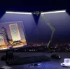 A desk setup at night with a computer monitor, keyboard, mouse, and a dual-headed desk lamp illuminating the scene. Voir les images du produit