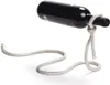 A black wine bottle is suspended horizontally by a thick white rope tied in a knot around its neck, with the rope forming a base on a white surface. Produktbild-Vorschau