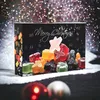 A Christmas advent calendar filled with colorful gummy candies, set against a sparkling, bokeh background. Snow and Christmas ornaments are in the foreground. Produktbild-Vorschau