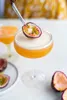 A passion fruit cocktail is being garnished with a slice of passion fruit. Podgląd zdjęcia produktu