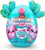 A teal-colored egg-shaped toy with blue and green fluffy appendages and pink accents, featuring illustrations of pink axolotl-like creatures. The packaging displays the brand name and product details. Anteprima dell’immagine prodotto
