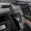 A smartphone is mounted on a car's dashboard using a gravity holder, displaying a navigation app. Náhľad obrázku produktu