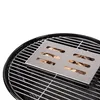 A smoker box filled with wood chips sits on a grill grate. Náhled obrázku produktu