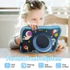 A young child is holding a blue toy camera with space-themed decorations. Produktbild-Vorschau