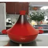 A red tajine pot with a black gradient lid sits on a kitchen counter. Náhled obrázku produktu