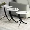 Three white nesting tables with black curved legs are arranged in a living room setting next to a sofa. Produktbild-Vorschau