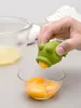A person is using a frog-shaped egg separator to separate egg yolks from egg whites. Produktbild-Vorschau