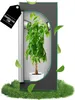 A potted plant inside a grow tent, with leaves floating around it. Voir les images du produit