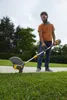 A man is using a string trimmer in a garden setting. Produktbild-Vorschau