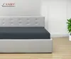 A bed with a gray fitted sheet is shown in a room with a white headboard and a plant in the background. Produktbild-Vorschau