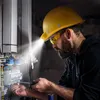 An electrician wearing a yellow hard hat with a built-in light is working on an electrical panel. Produktbild-Vorschau
