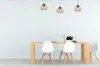 A dining table with chairs and pendant lights in a room with a white wall and wooden floor. Náhľad obrázku produktu