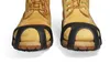 A close-up view of the front of two tan work boots with black traction devices attached to the soles. Produktbild-Vorschau
