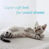 A kitten is lying on a soft, white surface with text overlayed on the background. Produktbild-Vorschau