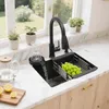 A kitchen sink area with a faucet, sink, dish rack with grapes, a glass being rinsed, a kettle, and lemons on a cutting board. Náhled obrázku produktu