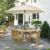An outdoor patio set with a round table, chairs, and a large umbrella, set on a stone patio in front of a house. Anteprima dell’immagine prodotto