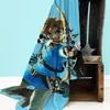 A blanket with an image of Link from The Legend of Zelda holding a bow and arrow, draped over a wooden crate. Anteprima dell’immagine prodotto