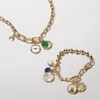 Two gold charm necklaces are displayed on a white background. Produktbild-Vorschau