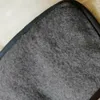 A close-up view of the corner of a grey wool blanket with a black border. Produktbild-Vorschau