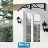 An awning is installed above a window on a building exterior, with two outdoor lamps mounted on the wall. Náhled obrázku produktu