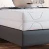 A close-up view of a white mattress on a gray bed frame. Produktbild-Vorschau