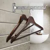 Two wooden hangers hang on a metal drying rack mounted on a tiled wall, with a white sink visible in the background. Produktbild-Vorschau