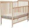 A wooden baby crib with a mattress and bedding. Anteprima dell’immagine prodotto