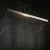 A close-up shot of a modern shower head with water streaming down, set against a dark background. Produktbild-Vorschau